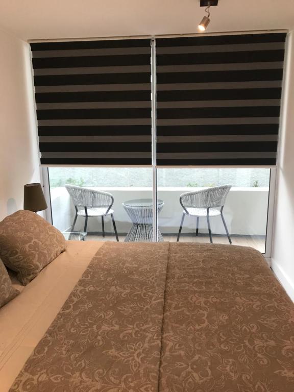 a bedroom with a bed and a window with a blind at 8,Clínica Las Condes, 3 personas in Santiago