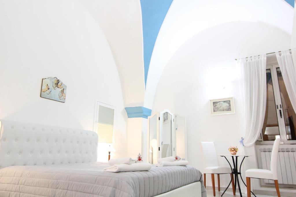 ロコロトンドにあるIl Balcone di Giuliettaの白いベッドルーム(ベッド1台、鏡付)