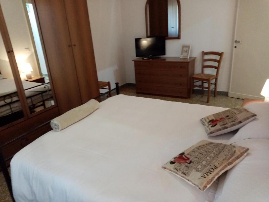 a bedroom with a large white bed and a television at L'Angolo Di San Pietro in Rome