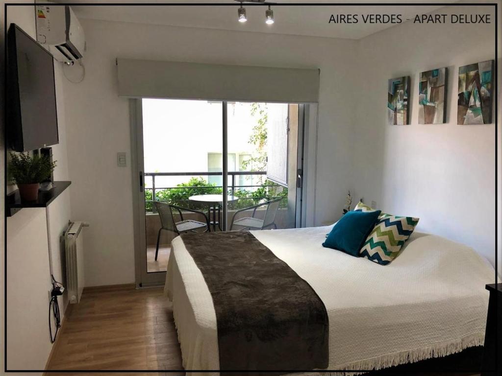 a bedroom with a large bed and a balcony at Aires Verdes Apart Deluxe in Salta