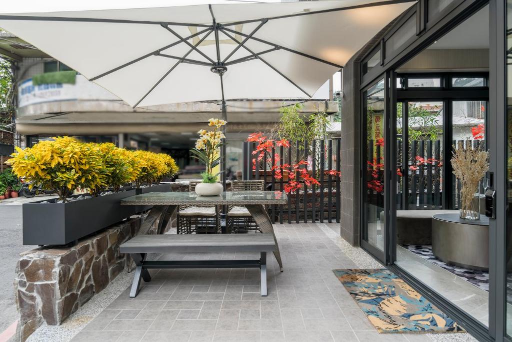 瑞芳區的住宿－愉園，一个带桌子和遮阳伞的庭院