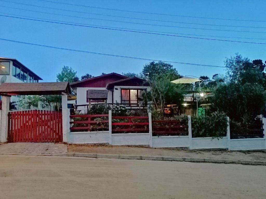 uma cerca branca em frente a uma casa em los troncos em El Tabo