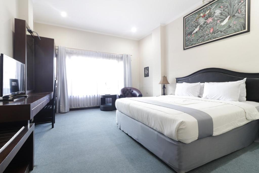 um quarto com uma cama grande e uma televisão em Hotel Antariksa em Dupak