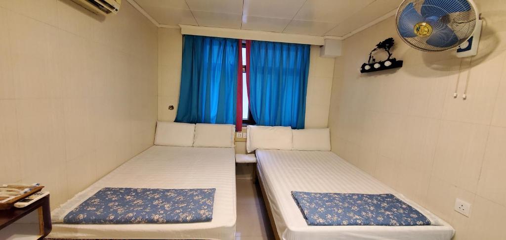 2 camas en una habitación pequeña con ventana en New hoover hostel en Hong Kong