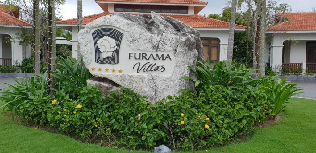 a sign in the grass in front of a building at Champa Villa with private pool at Furramar Danang in Danang