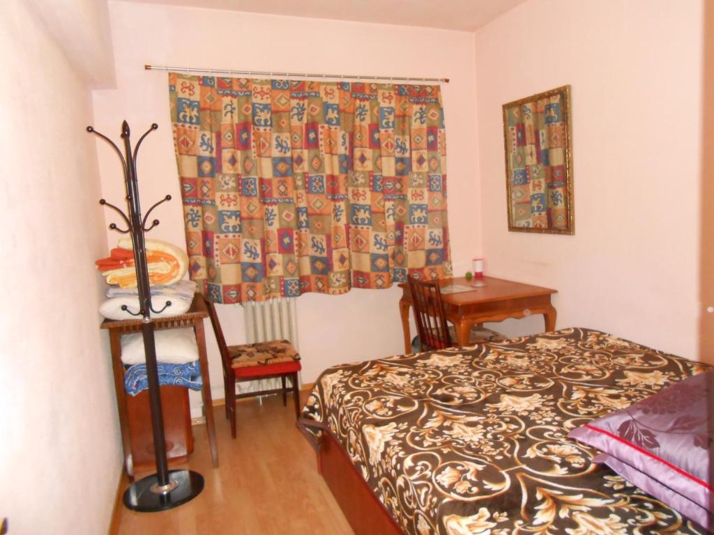- une chambre avec un lit, une table et une fenêtre dans l'établissement Host Tina, à Bucarest