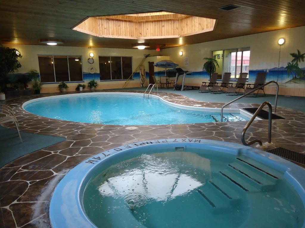 uma grande piscina num hotel com uma banheira de hidromassagem em Canway Inn & Suites em Dauphin