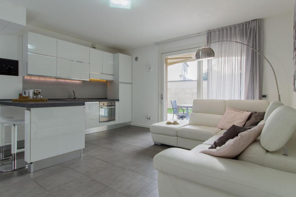 sala de estar blanca con sofá blanco y cocina en Venturini Guest House Self Check-in, en Piacenza