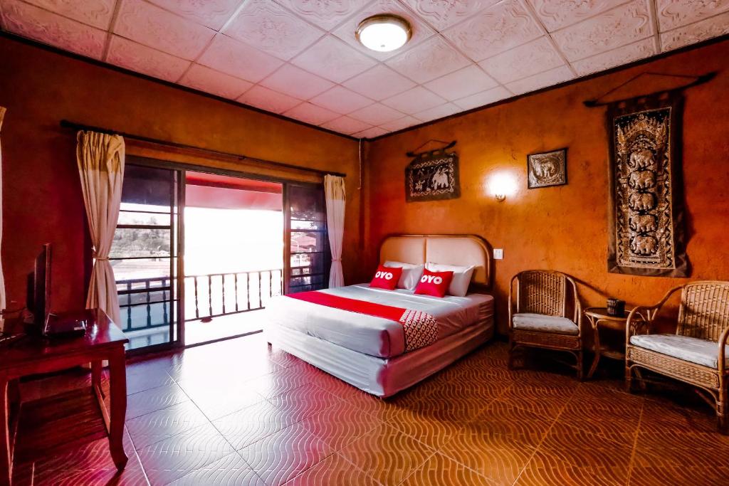 a bedroom with a bed with red pillows and a window at OYO 490 Chiangsan Golden Land Resort2 in Chiang Saen