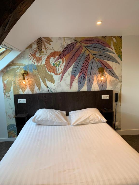 a bedroom with a large white bed with a mural at Hotel Iena in Angers