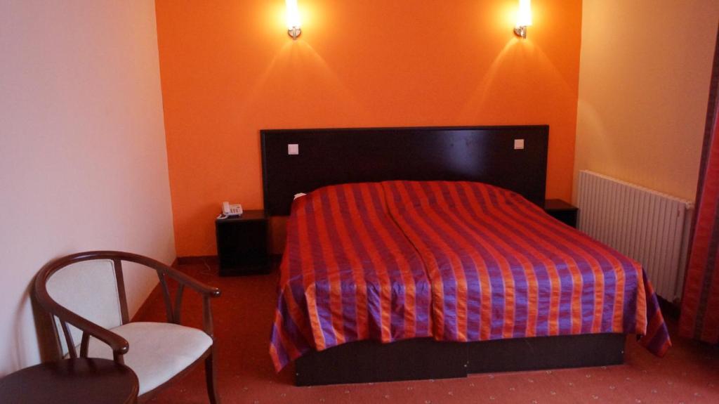 プレデアルにあるPensiunea Kasa Verde Predealのベッドルーム1室(赤い毛布と椅子付きのベッド1台付)