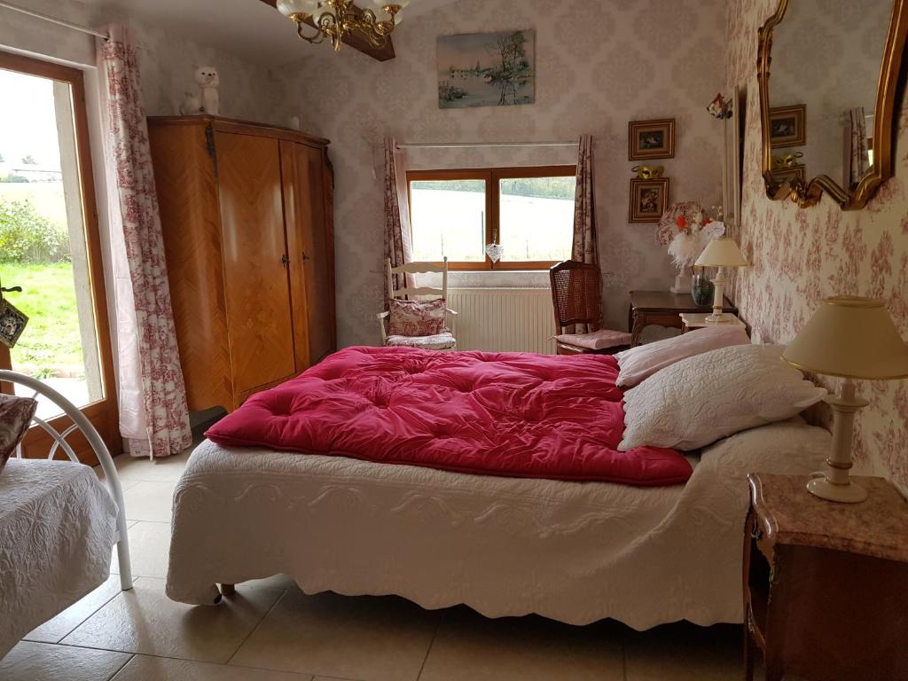 sypialnia z dużym łóżkiem i czerwonym kocem w obiekcie LA PROVIDENCE w mieście Illiat
