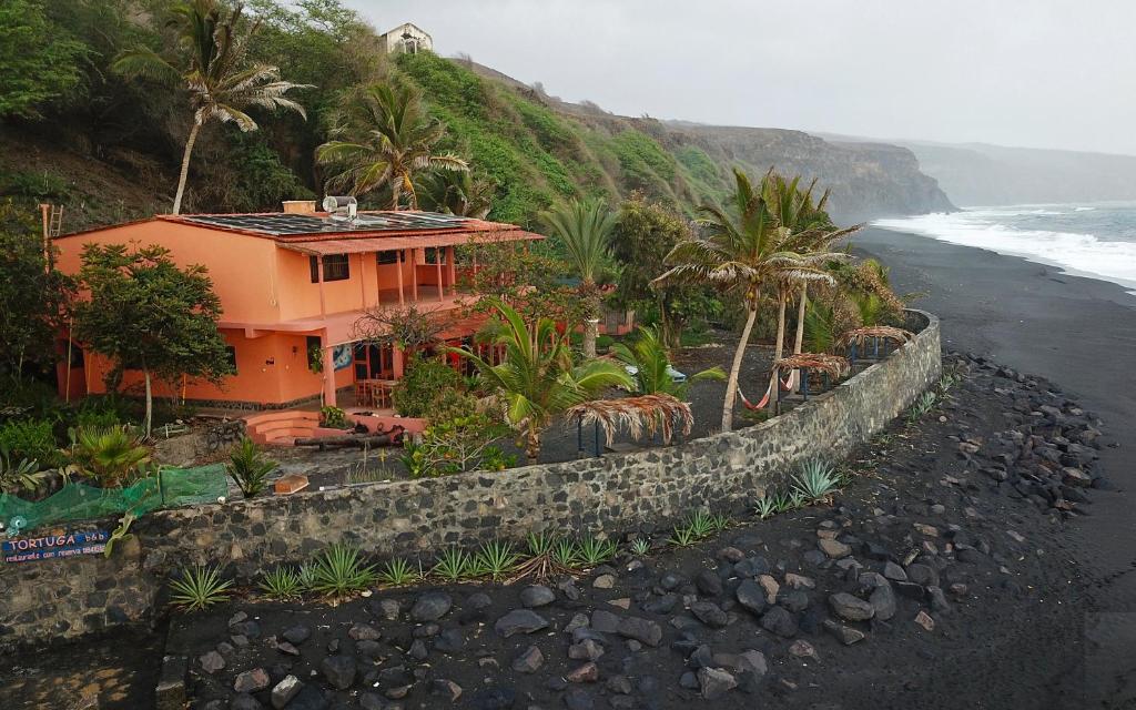 a house on a hill next to the ocean at Tortuga B&B in São Filipe