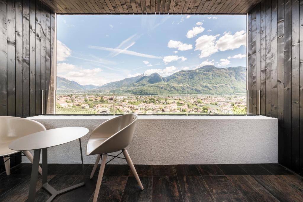 a room with a large window with a view of mountains at Garni Hotel Katzenthalerhof in Lana