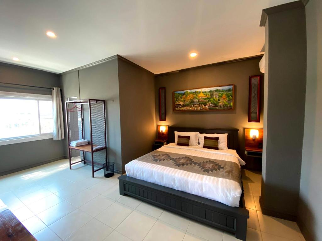 a bedroom with a bed and a painting on the wall at Patuxay Place in Vientiane