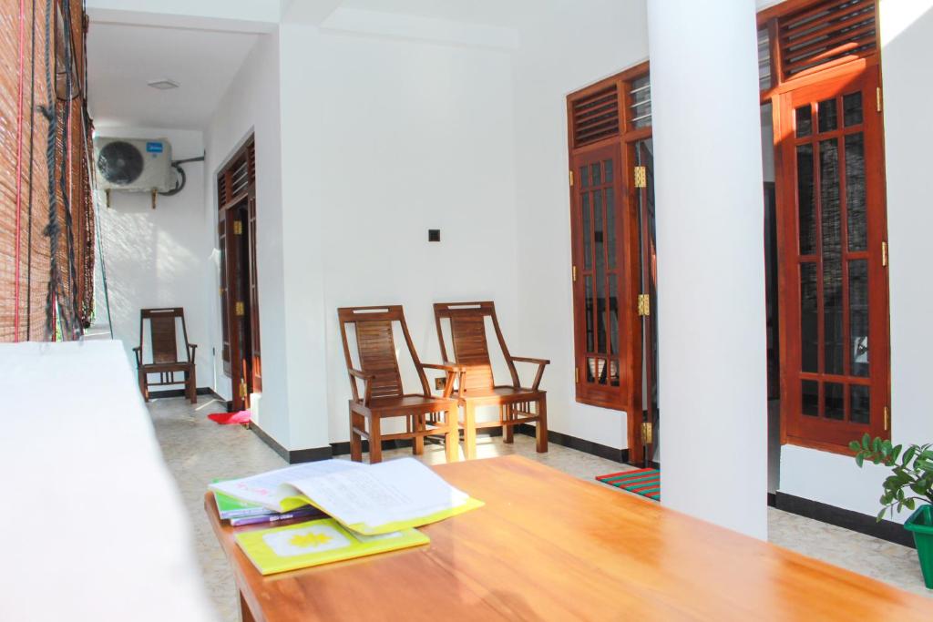 een kamer met een houten tafel en stoelen en een tafel bij Temple Tree Mirissa in Mirissa