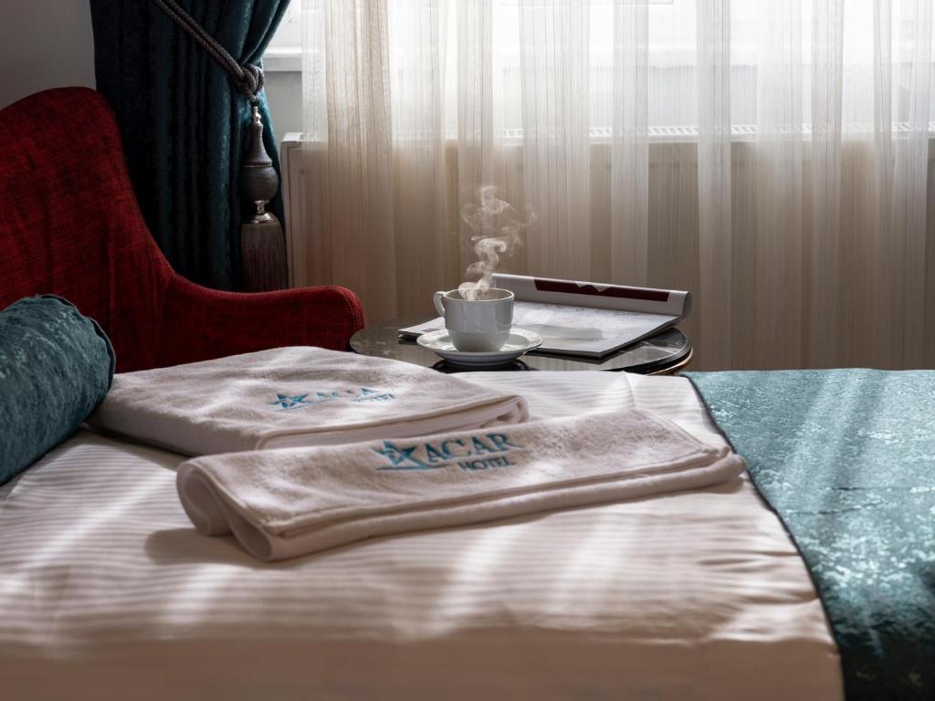 two towels sitting on a bed with a table at acar hotel Kırıkkale in Kırıkkale