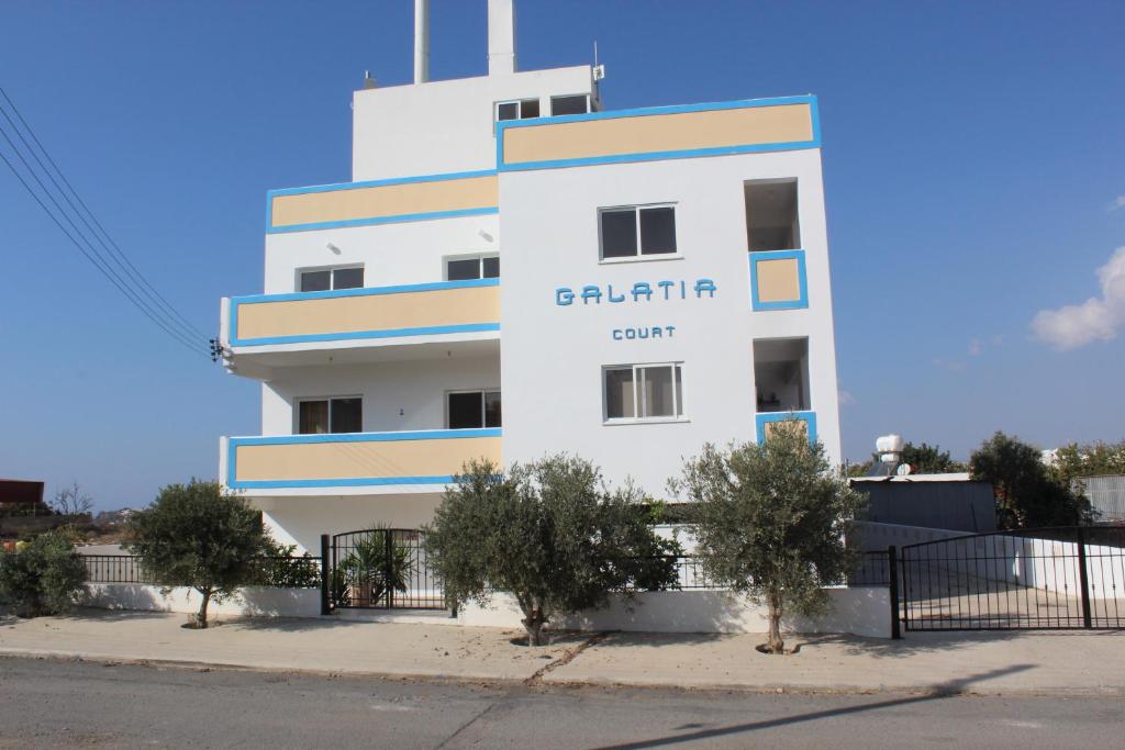 un edificio blanco con las palabras alquiler de Baltimore en Galatia's Court, en Pafos