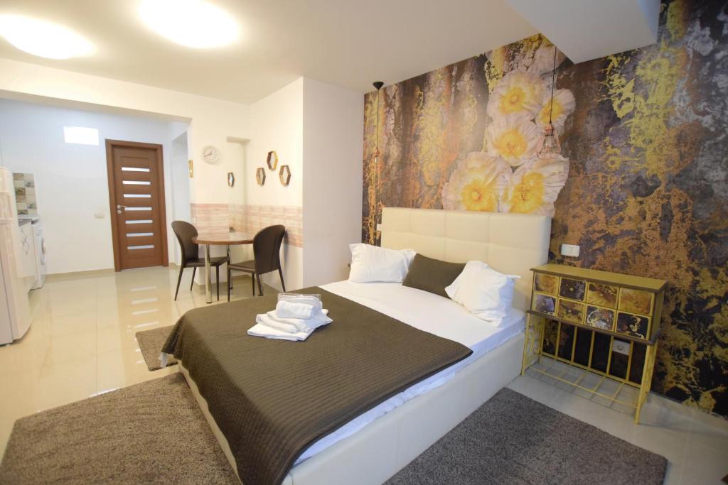 1 dormitorio con 1 cama y 1 mesa con sillas en Decebal Residence Apartments en Bucarest