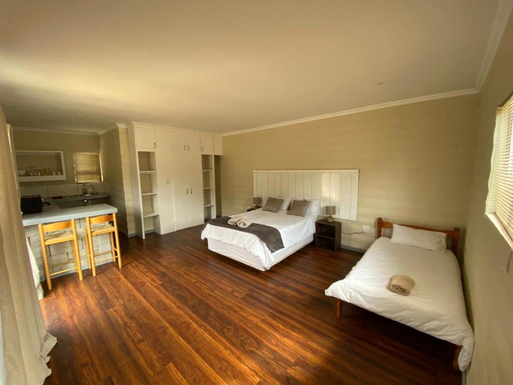 1 dormitorio con 2 camas y cocina. en Biesiesvlei 2, en Plettenberg Bay