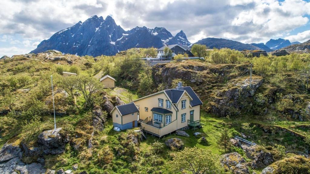 a house on a hill with mountains in the background at Sea-view house in Sund in Sund