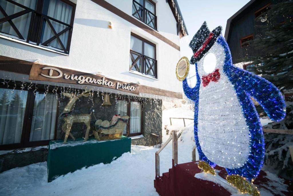 a snowman in front of a building in the snow at Drugarska prica-Lana in Jahorina