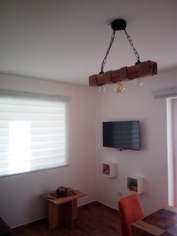 a living room with a television and a table at Iznad oblaka A1 in Kopaonik