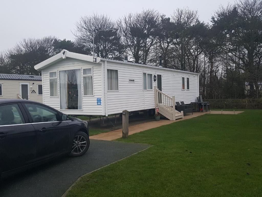 uma casa branca com um carro estacionado em frente dela em Rydal 38 Haven lakeland LA11 7LT em Flookburgh