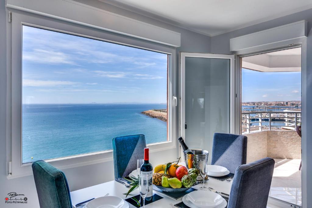 ein Esszimmer mit einem Tisch und Meerblick in der Unterkunft La Paz Molo in Torrevieja