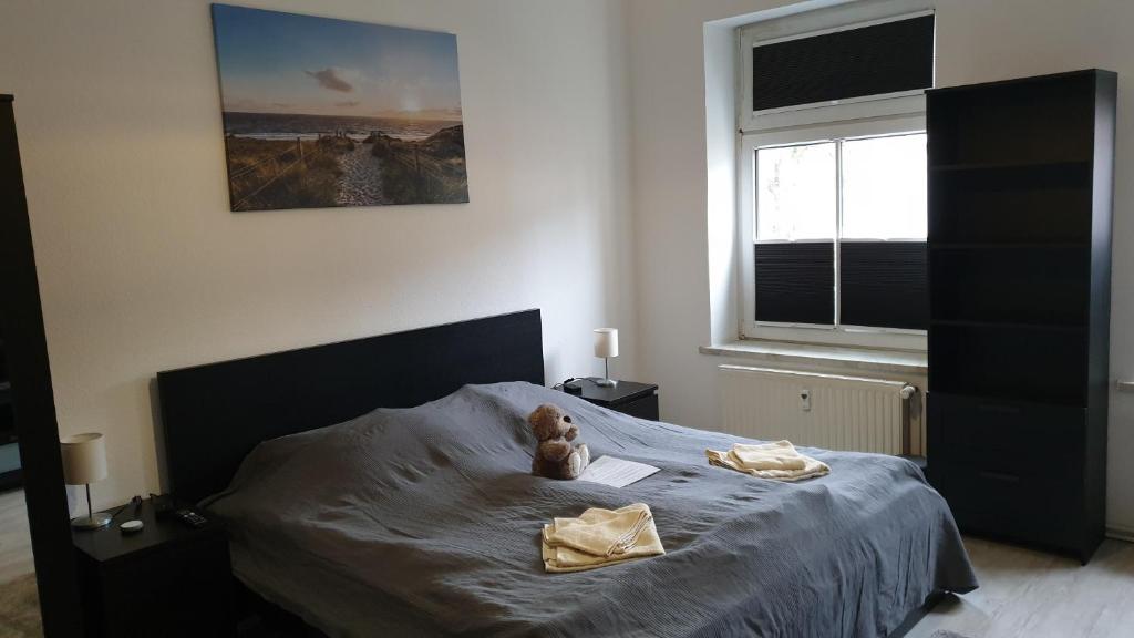 un osito de peluche sentado en una cama en un dormitorio en Goethe 2 - Mitten im Zentrum von Schwerin, en Schwerin