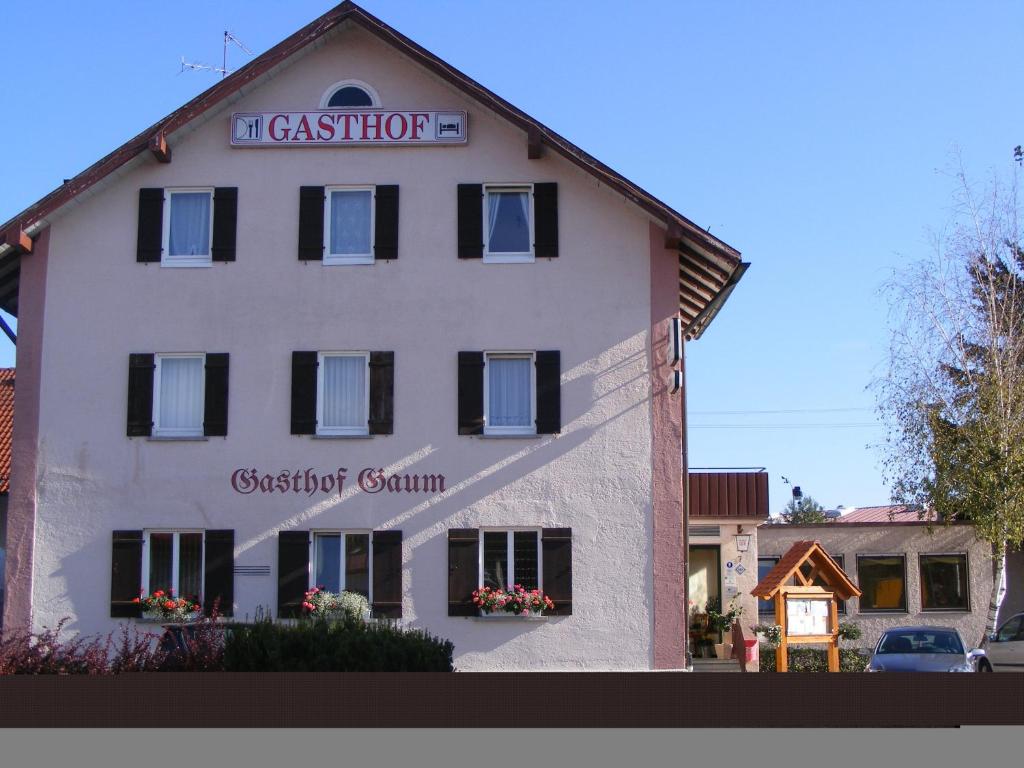 ein großes weißes Gebäude mit einem Schild drauf in der Unterkunft Hotel Gaum in Biberach-Ummendorf