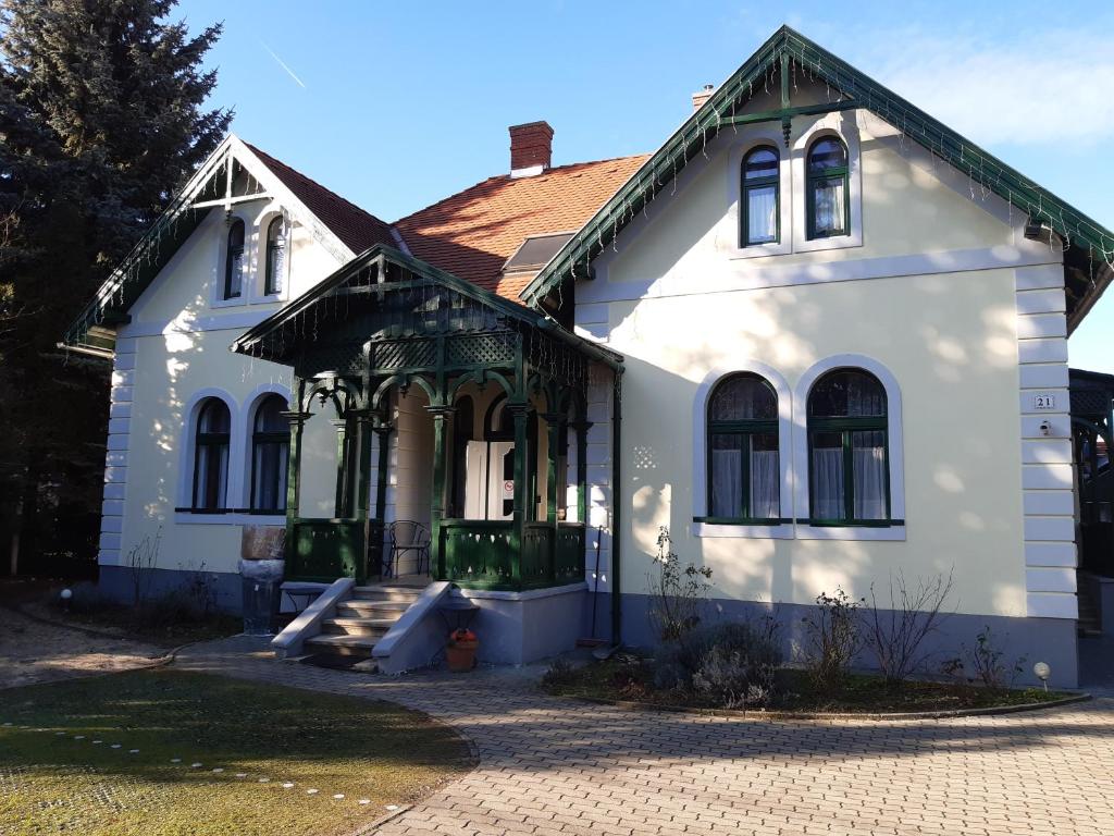 ein weißes Haus mit rotem Dach in der Unterkunft Szalay Villa in Veszprém