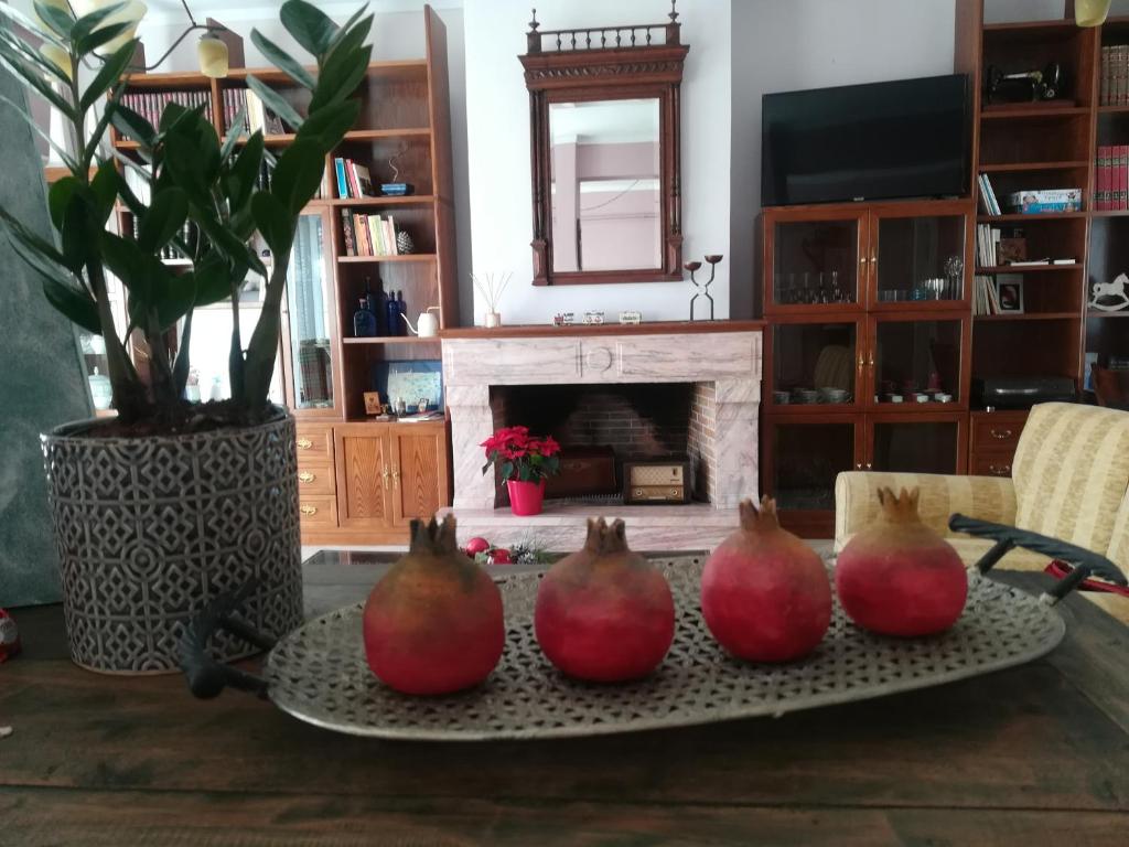 four pomegranates on a tray on a table with a fireplace at Areti' s Home in Volos
