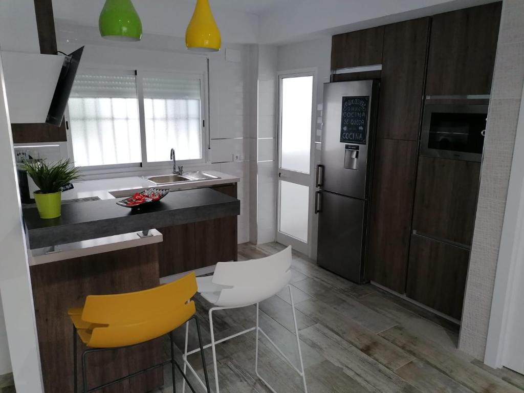 a kitchen with a counter and a yellow chair at Mezquita- Elite, Parking, Wifi in Córdoba