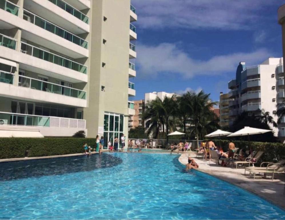 a large swimming pool with people in a hotel at Apartamento em Resort Ilha da Madeira na Riviera in Riviera de São Lourenço