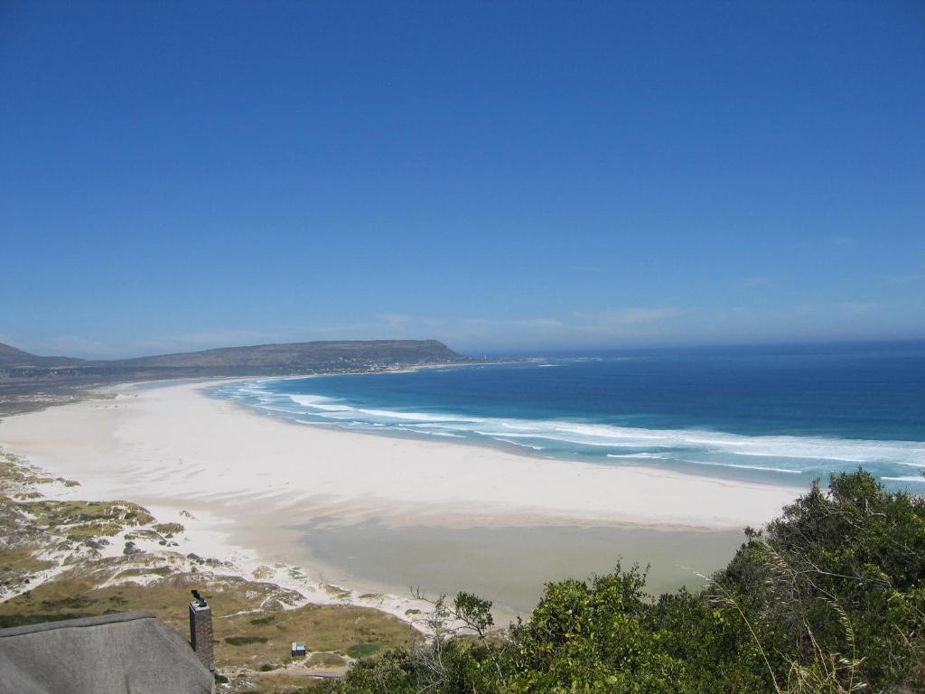 uma vista para uma praia com o oceano em Sacred Mountain Lodge em Noordhoek