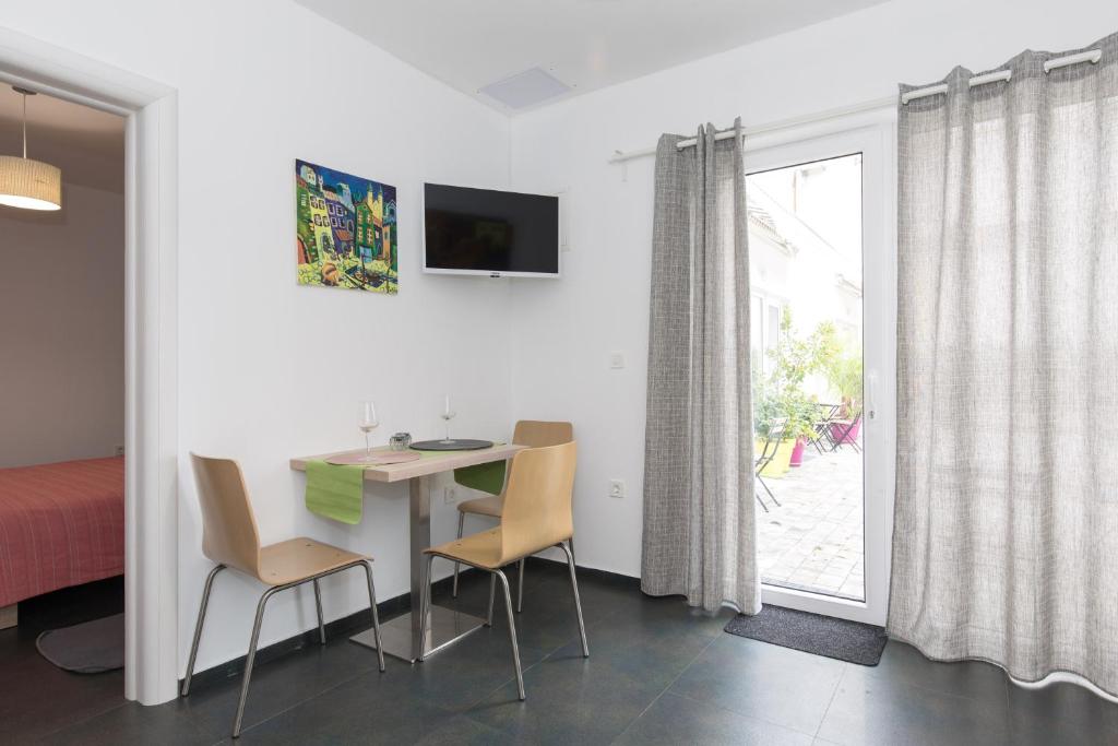 um quarto com uma mesa e cadeiras e uma cama em Apartment Lauro Opatija, ground floor, parking, near sea em Opatija