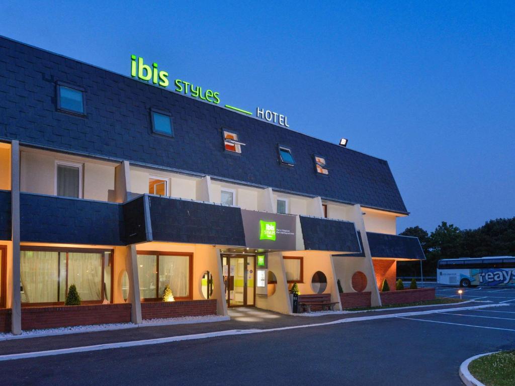 un hôtel avec un panneau en haut dans l'établissement ibis Styles Parc des Expositions de Villepinte, à Villepinte