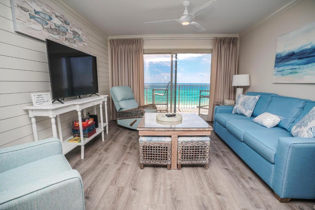 een woonkamer met een blauwe bank en een tv bij Summerlin Condominiums by Panhandle Getaways in Fort Walton Beach