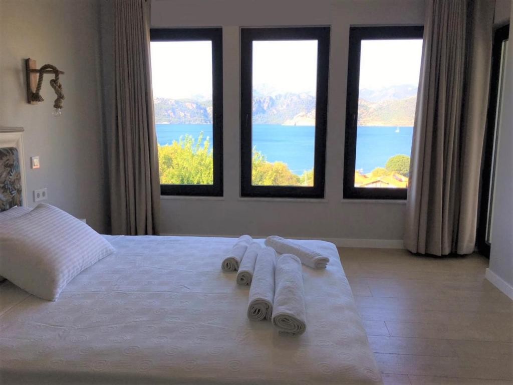 a bedroom with three towels on a bed with windows at Gala Selimiye in Selimiye