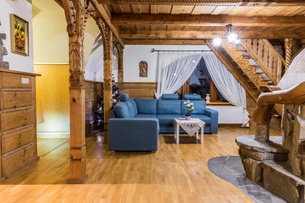uma sala de estar com um sofá azul e escadas em Apartament Bajkowy & Dwupoziomowy Krzesany em Zakopane