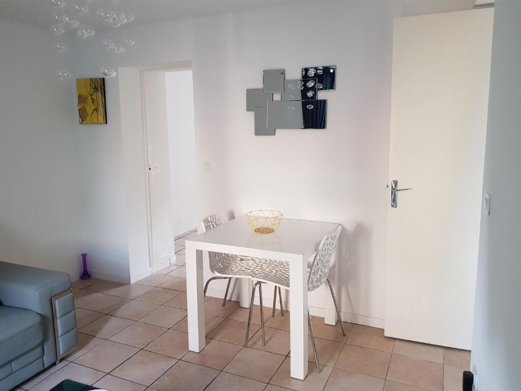una mesa blanca y sillas en una habitación en Jolie appartement moderne à Roanne, en Roanne