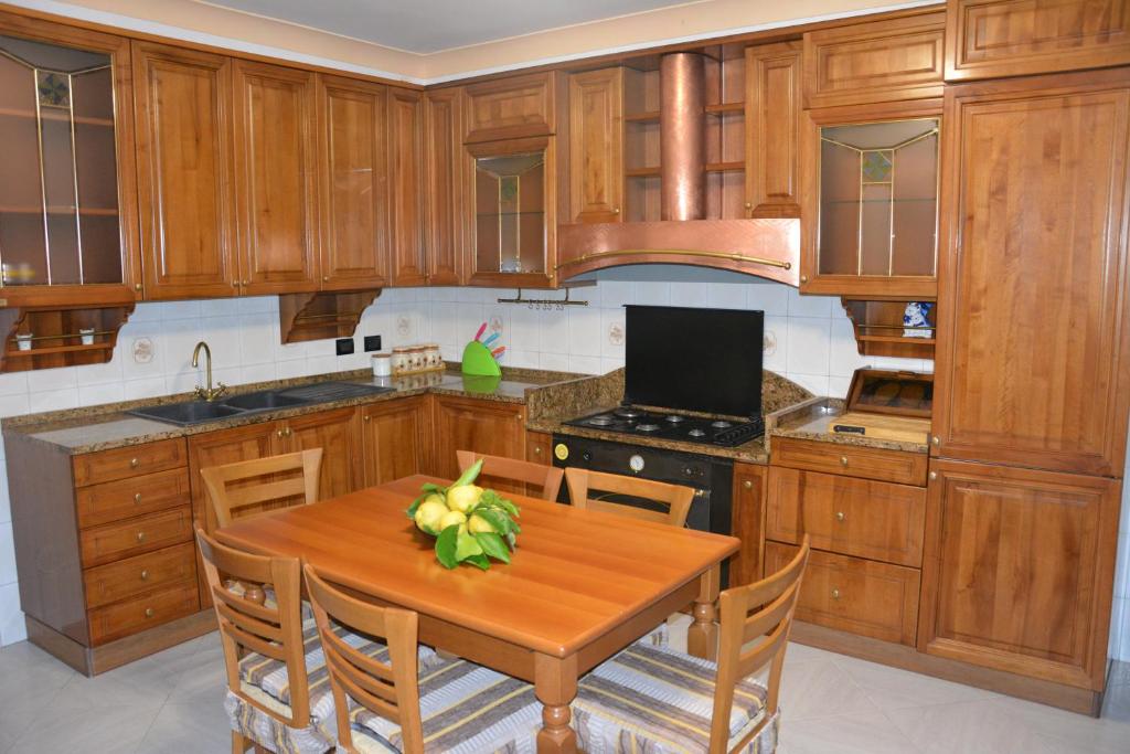 a kitchen with wooden cabinets and a wooden table at Antica Casa Cavaliere in Tramonti
