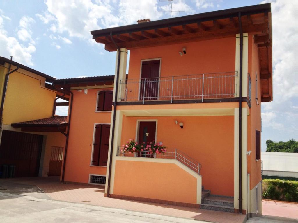 une maison avec un balcon sur le côté de celle-ci dans l'établissement Appartamento Serena, à Ponti sul Mincio