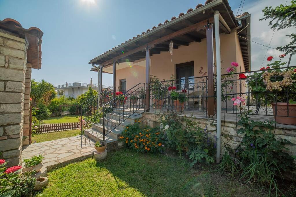 a house with a balcony with flowers in the yard at Family House with Garden in Igoumenitsa