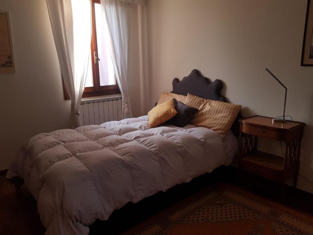 sypialnia z łóżkiem i poduszkami w obiekcie Tenuta Crescentini-ValleMura ,appartamenti con entrata indipendente w mieście San Donà di Piave