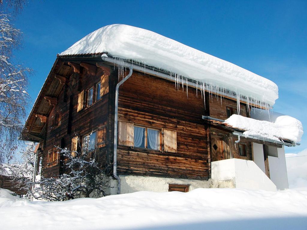 a log cabin with icicles hanging from it in the snow at Casa Cadruvi, Ferienhaus in Obersaxen, 150 Quadratmeter in Obersaxen