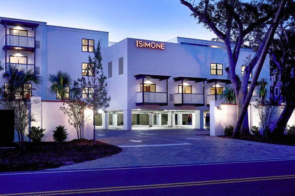 een wit gebouw met een bord waarop staat: rook bij Hotel Simone in Saint Simons Island