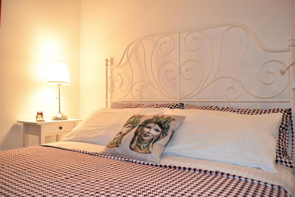 a bed with a headboard with a picture of a woman at IL MORO holiday home in Siracusa