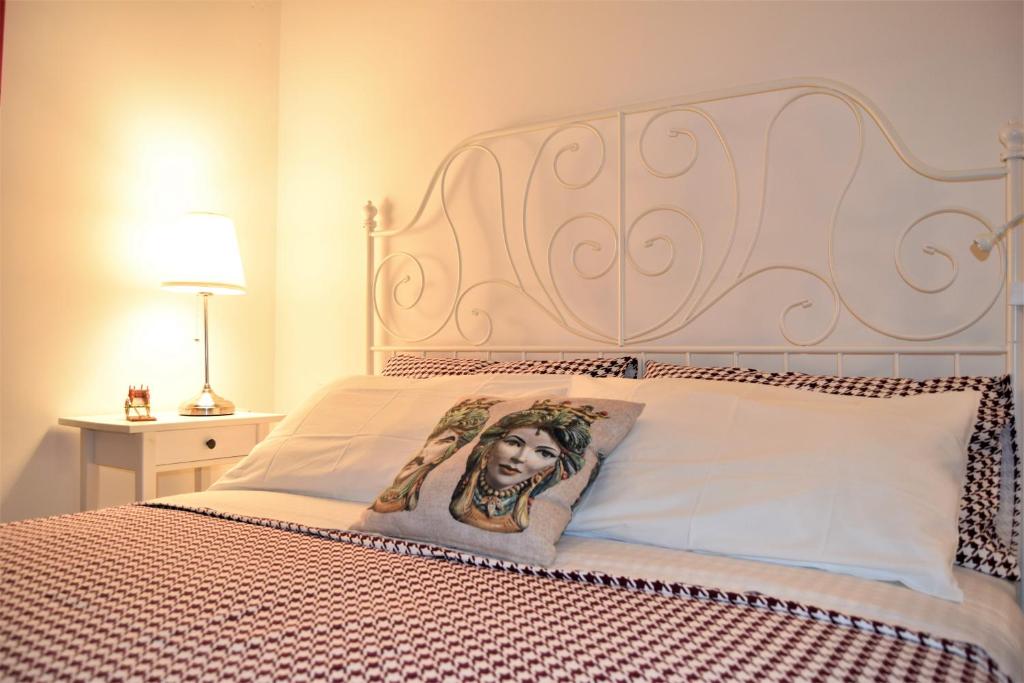 シラクーサにあるIL MORO holiday homeの女性の写真を掲げたベッド